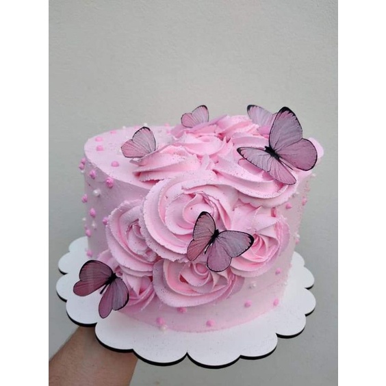 Decoração de bolo rosa em forma de borboletas