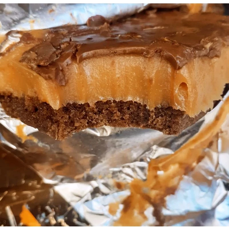 Close em uma unidade da torta mostrando a textura do recheio de caramelo e a cobertura de chocolate