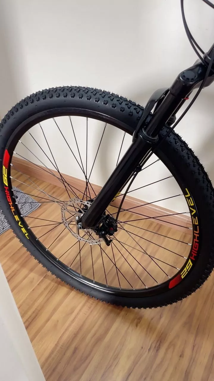 Roda traseira da bicicleta KGT com aro 29, freio a disco e pneu com banda de rodagem para trilha, em detalhe próximo