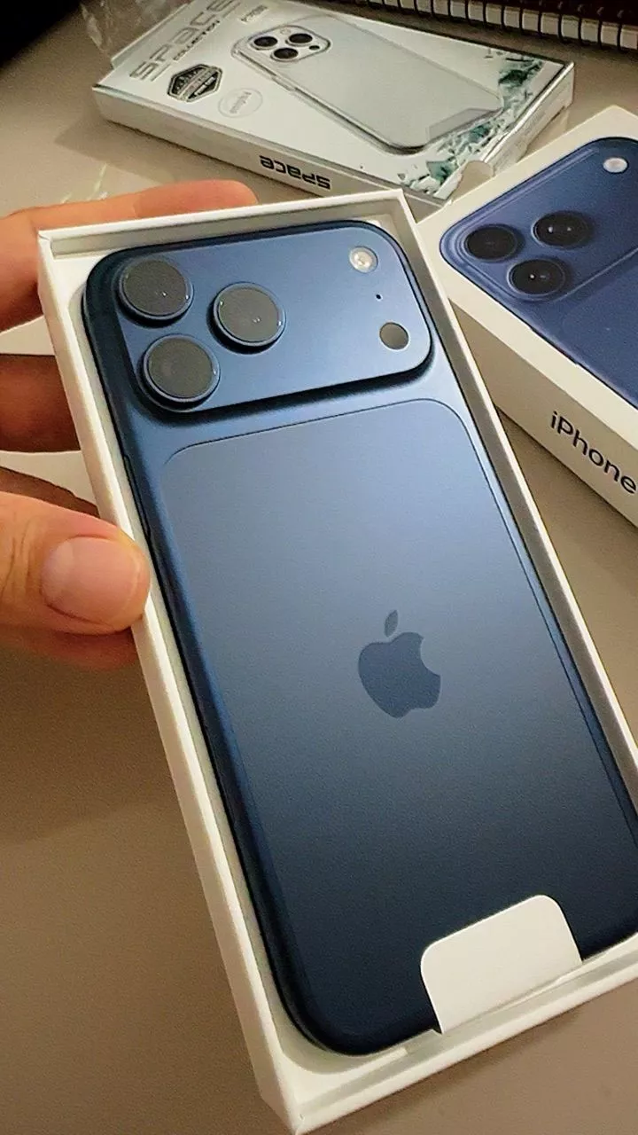 Caixa original do iPhone 17 Pro Max azul sendo aberta com o aparelho ao lado