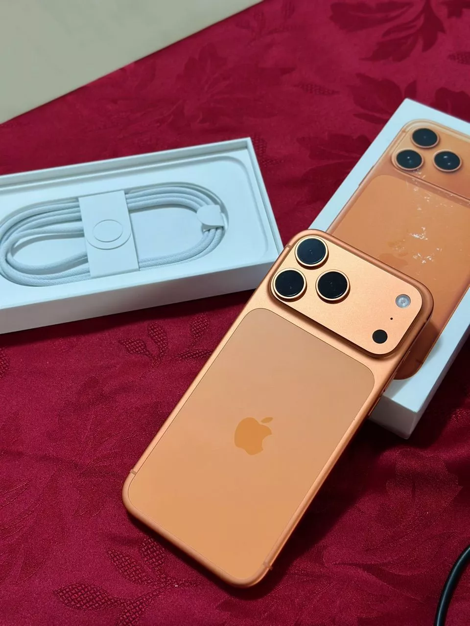 iPhone 17 Pro Max dourado ao lado de sua caixa e acessórios originais