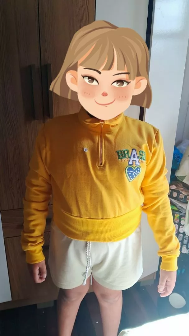 Pessoa usando cropped de moletom amarelo com zíper e shorts claros para foto de corpo inteiro