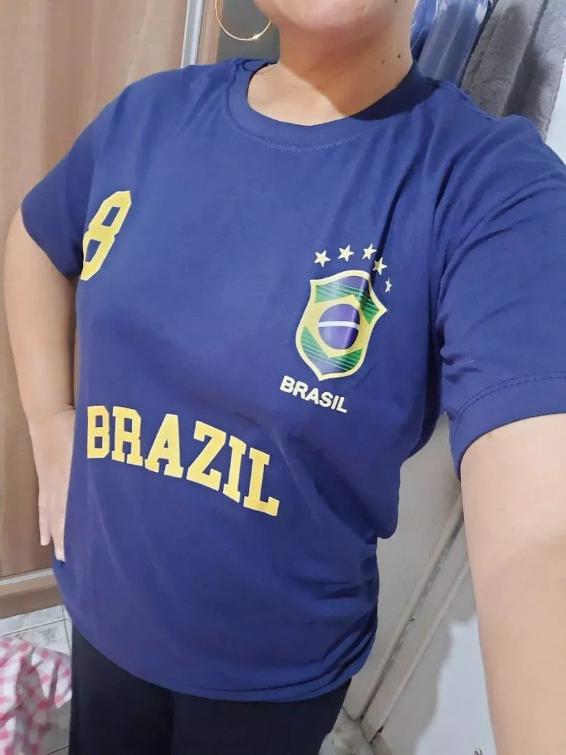 Close no tronco da modelo vestindo blusa azul marinho com escudo do Brasil e número 8