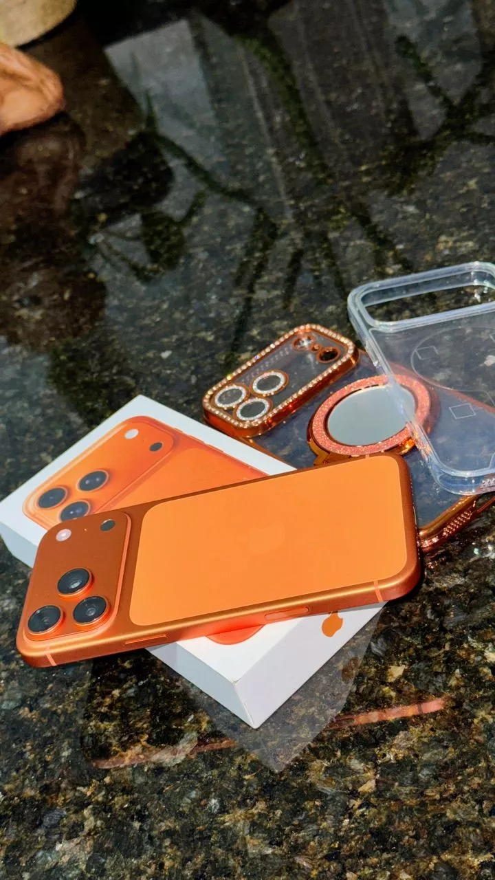 Parte traseira do iPhone 17 Pro Max laranja com módulo de câmera tripla e flash