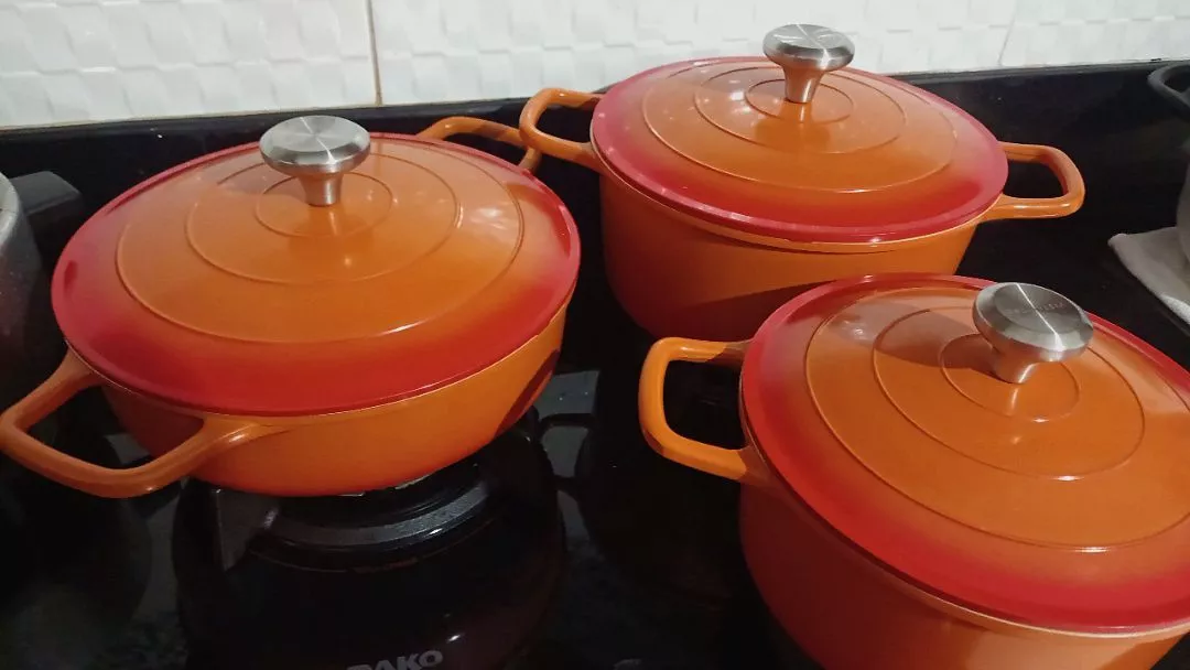 Conjunto de 3 panelas de cerâmica laranja e vermelha em uma cozinha