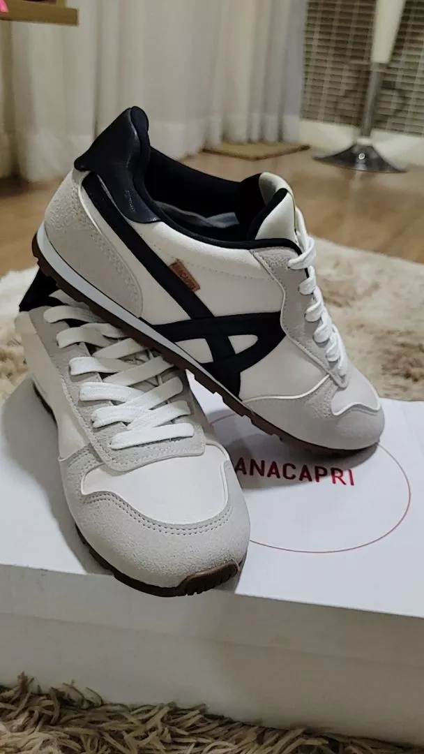 Dois tênis Anacapri Lola cinza e branco empilhados sobre uma caixa da marca.