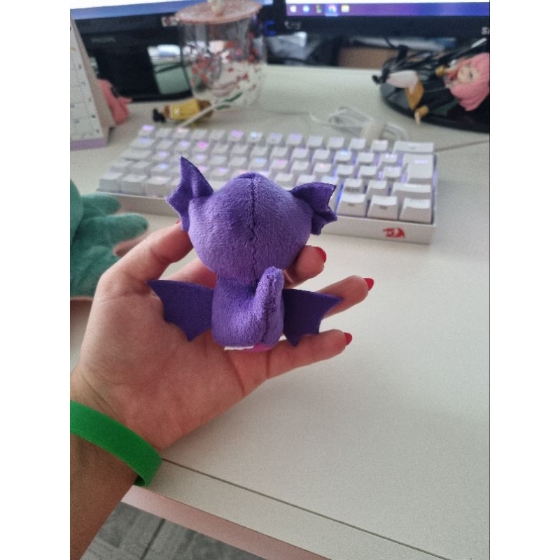 Um gato preto com olhos laranja está em um pokemon espeon de fundo preto