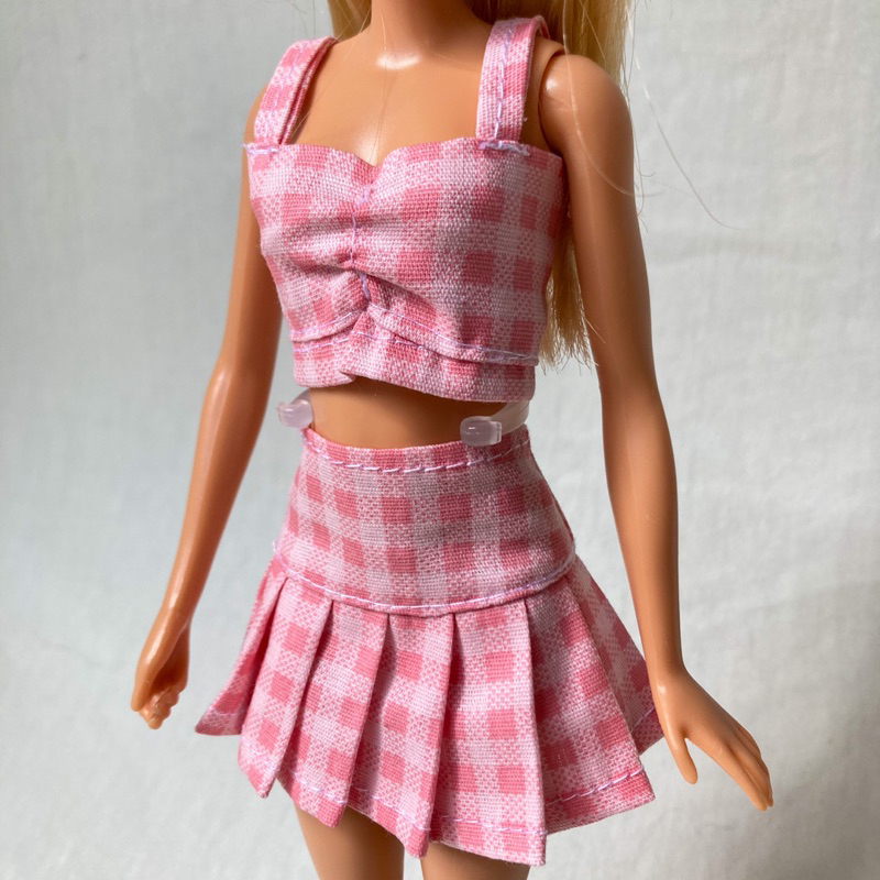 Um conjunto de roupas rosa para uma boneca roupas de moda feminina