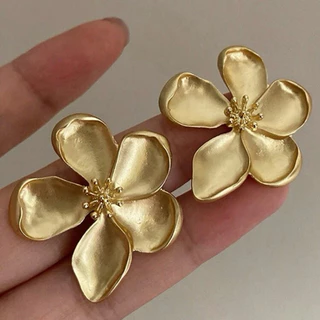 Par de brincos dourados em formato de flor de tamanho médio de aço cirúrgico folheado a ouro.