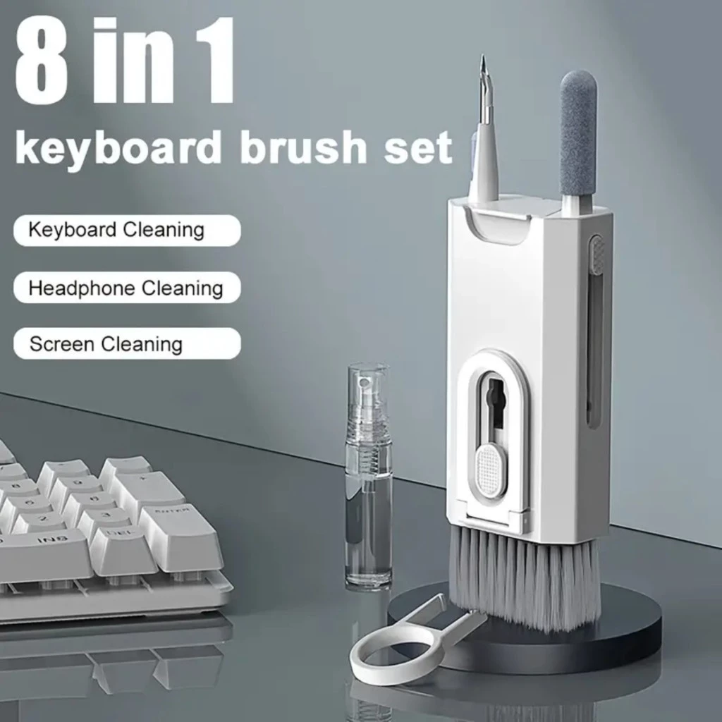 Kit de escova de teclado 8 em 1 em pé ao lado de um spray higienizador, extrator de teclas e um teclado mecânico branco.