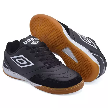 Par de chuteiras de futsal Umbro pretas com sola de borracha marrom e detalhes brancos.