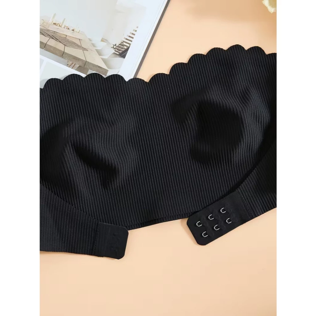Sutiã top sem alça preto exibindo os colchetes do fecho frontal