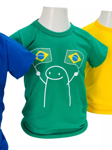 Mannequim veste camisa verde com bandeiras, ao lado de amarelo e azul, fundo branco.