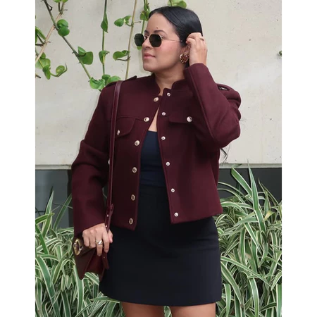 Detalhe da jaqueta estruturada marrom com botões dourados