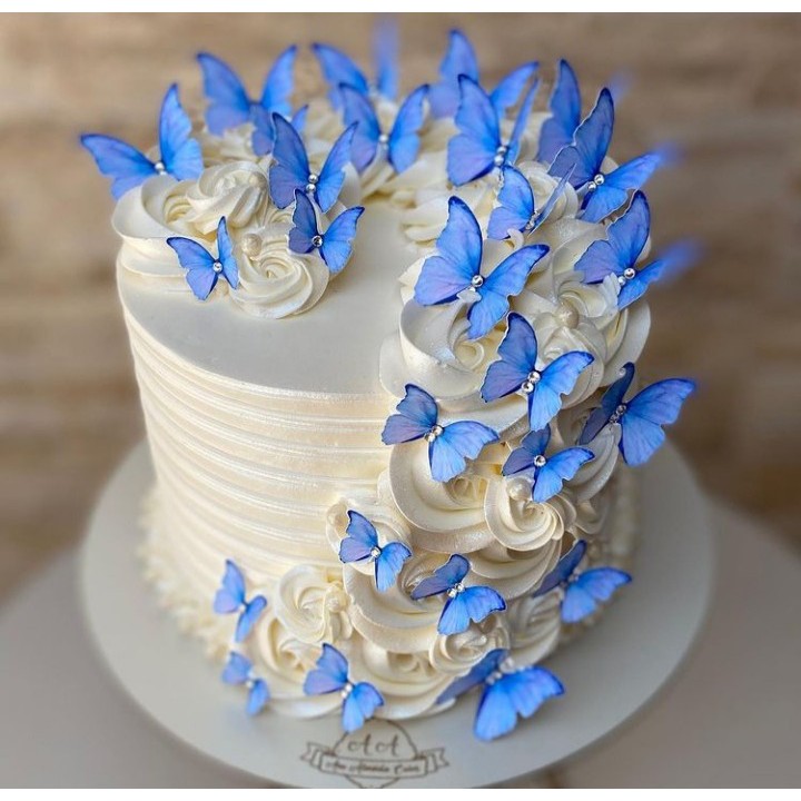 Um bolo azul e dourado com borboletas