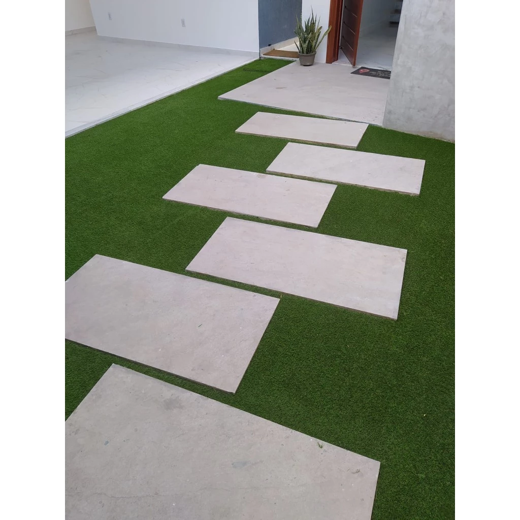 passo de pedra em grama sintética verde
