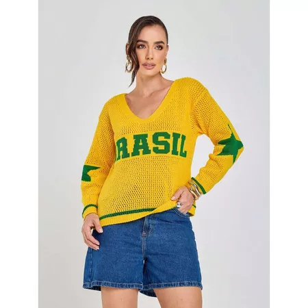 Modelo vestindo blusa de tricot amarela com a palavra BRASIL na frente e estrelas verdes nas mangas, combinada com shorts jeans