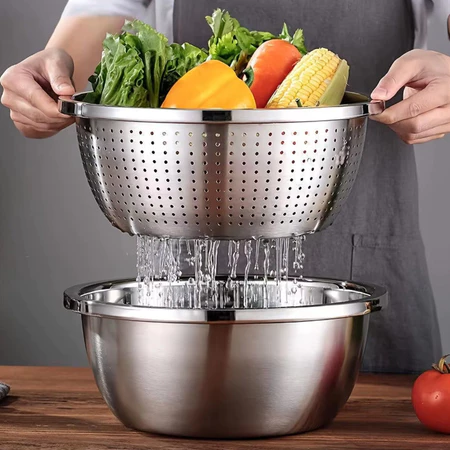 Pessoa segurando um escorredor de inox com legumes frescos sendo lavados sobre uma tigela