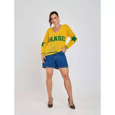 Modelo de corpo inteiro posando de frente com a blusa Brasil e shorts jeans, mostrando o visual completo e o comprimento da peça