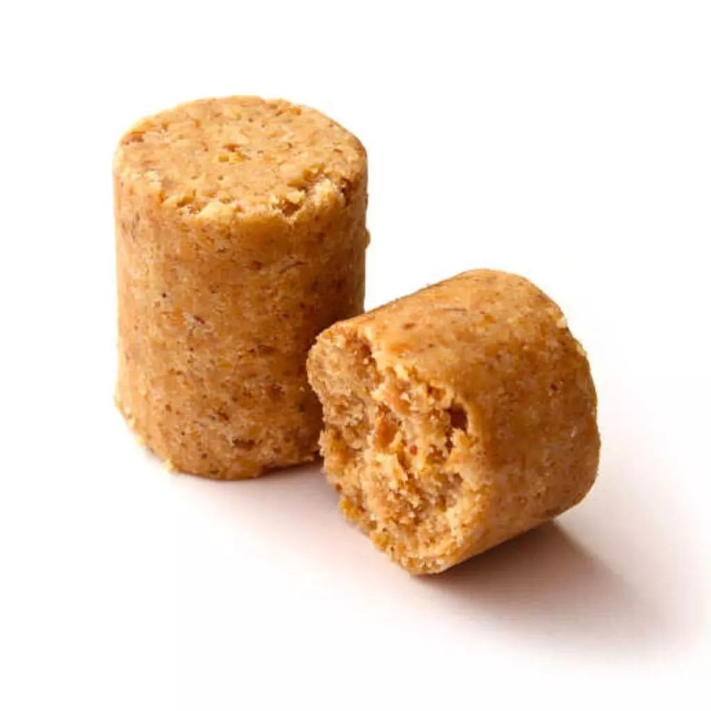 Dois cilindros marrons de paçoquita, um inteiro e outro partido