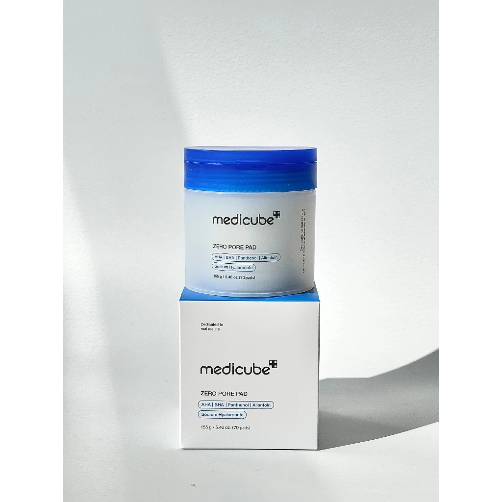 Pote de Medicube Zero Pore Pad com tampa azul escuro posicionado sobre sua caixa branca.